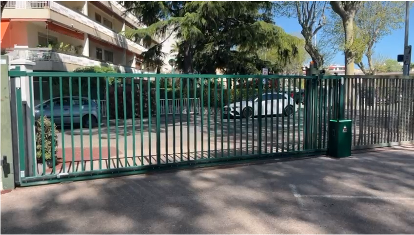Portail coulissant motorisé Ferplay vert foncé barreaudé installé à l'entrée d'une résidence à Cagnes-sur-Mer
