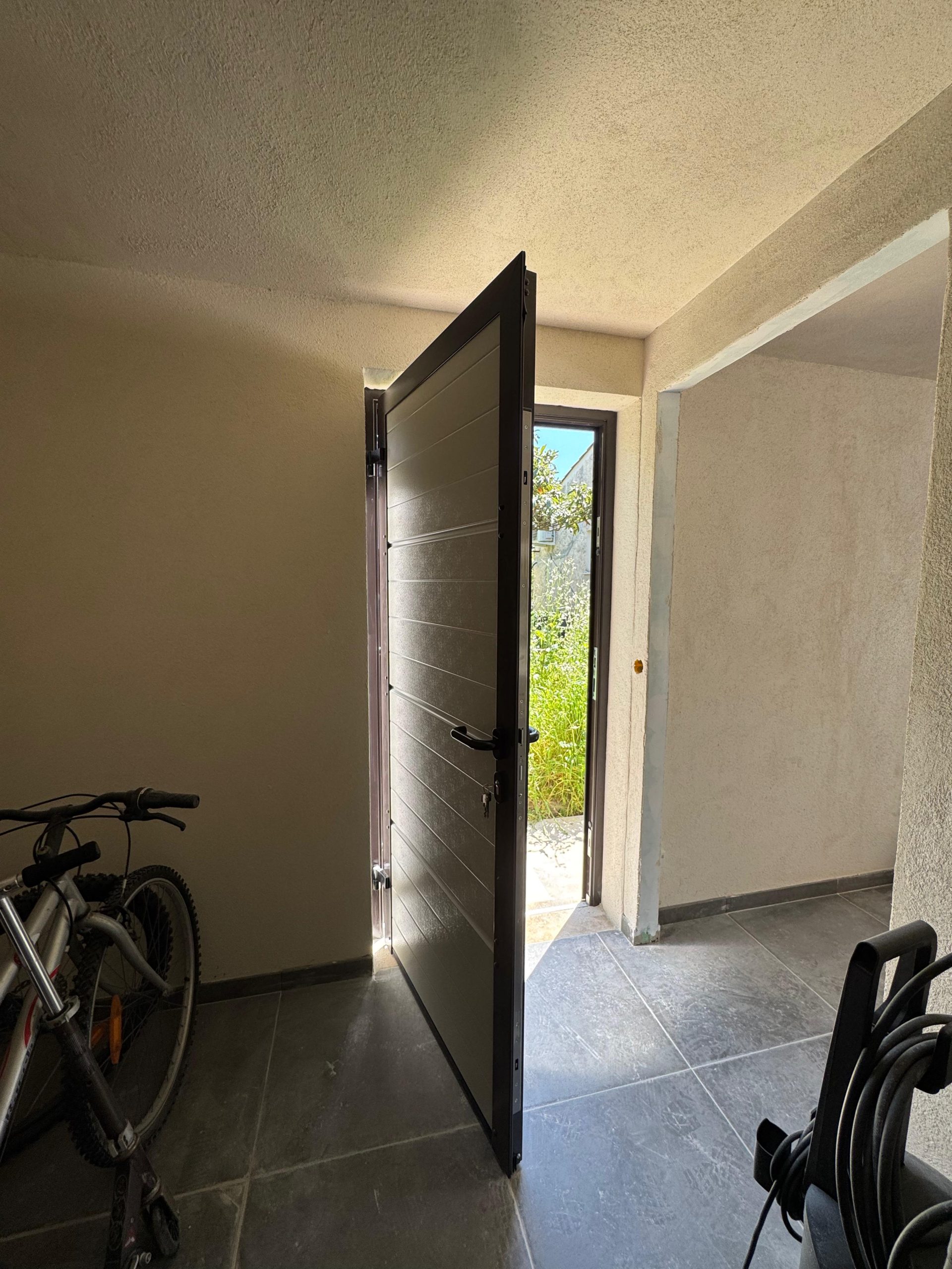 Porte de service Hörmann en aluminium avec facette blanche intérieure et RAL 8019