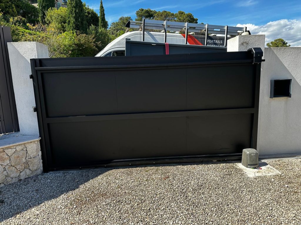 Installation du portail coulissant Kostüm Archy avec motorisation Somfy visible au sol, chantier à Mougins